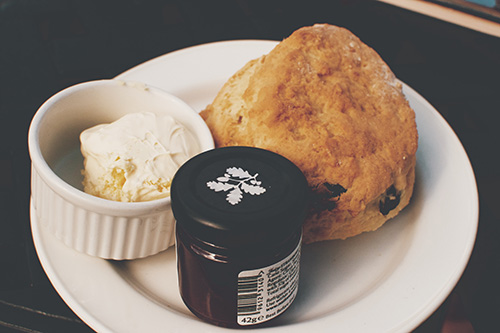 Scone on plate with cream and jam